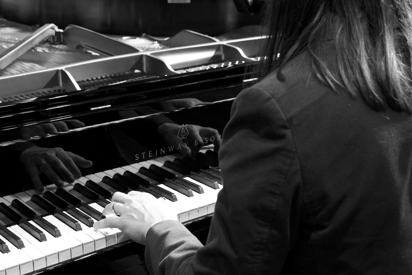 Hands at the keys of a grand piano at PVT Studio in Pasadena